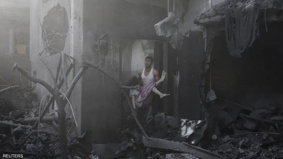 صورة حول : صور الألم: جوائز تكرم رويترز لتوثيق مأساة "حرب غزة" فلسطيني يحمل جثة امرأة قتلت في قصف إسرائيلي