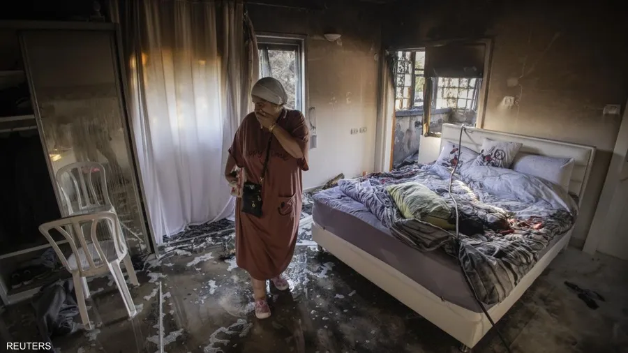 صورة حول : صور الألم: جوائز تكرم رويترز لتوثيق مأساة "حرب غزة" إسرائيلية تتفقد منزل في عسقلان بعد قصف صاروخي