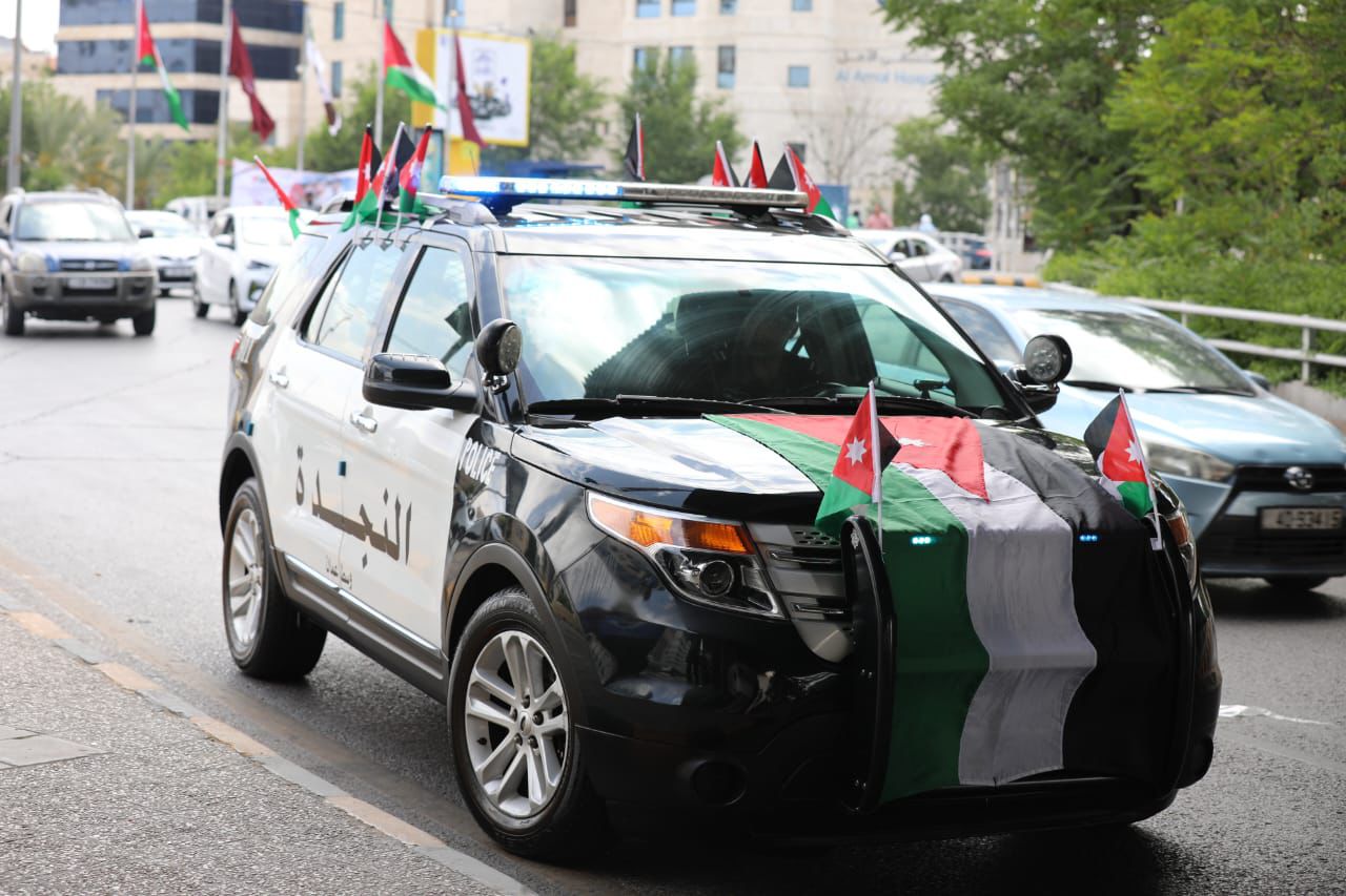 رجال الأمن يوزعون أعلام الوطن ويرفعونها مع أهلهم وعزوتهم