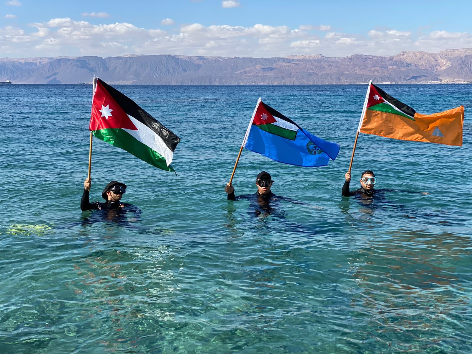 رجال الأمن يوزعون أعلام الوطن ويرفعونها مع أهلهم وعزوتهم