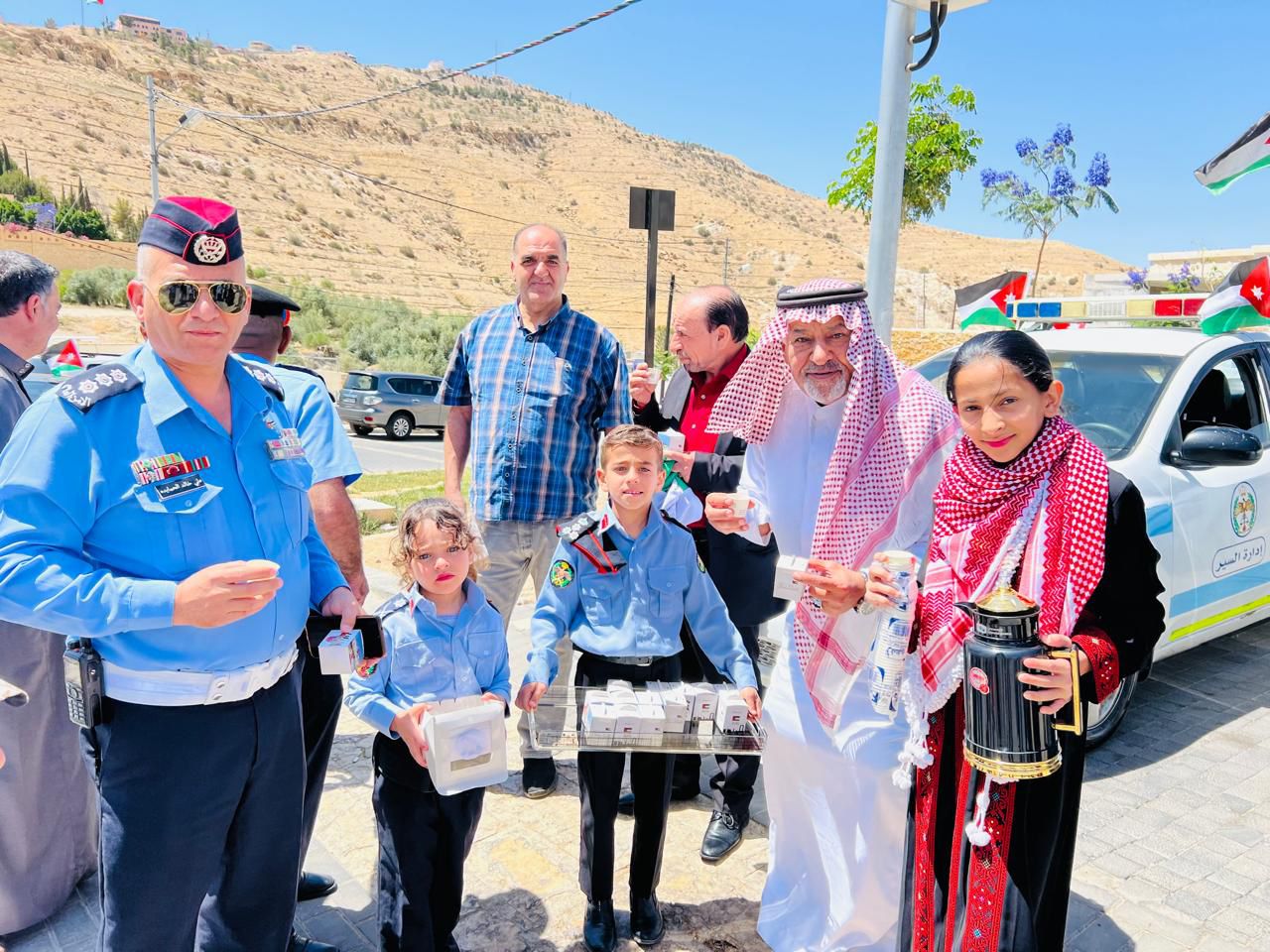 رجال الأمن يوزعون أعلام الوطن ويرفعونها مع أهلهم وعزوتهم
