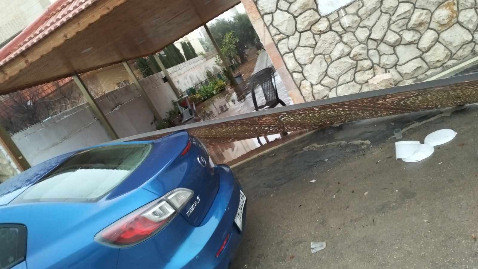 رياح شديدة تسقط بوابة منزل على سيارة في الكرك